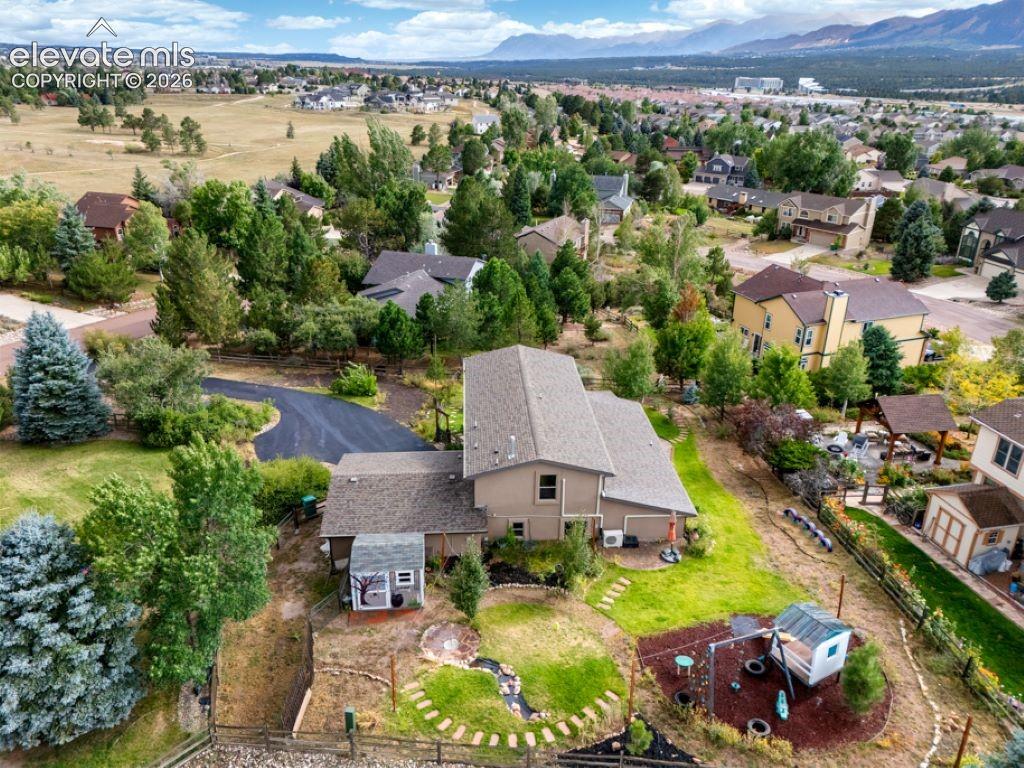 Image 4 of 50: Expansive exterior featuring a paved driveway, a large backyard with lush g