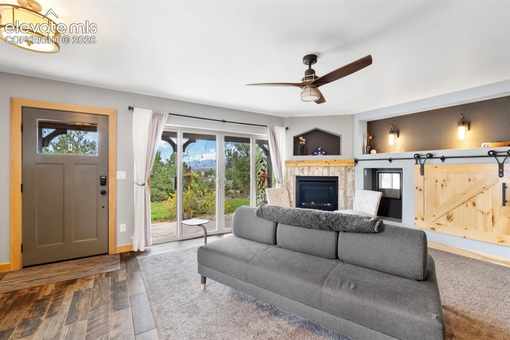 Image 40 of 50: Wood-finish flooring, sliding glass doors to the exterior, built-in firepla