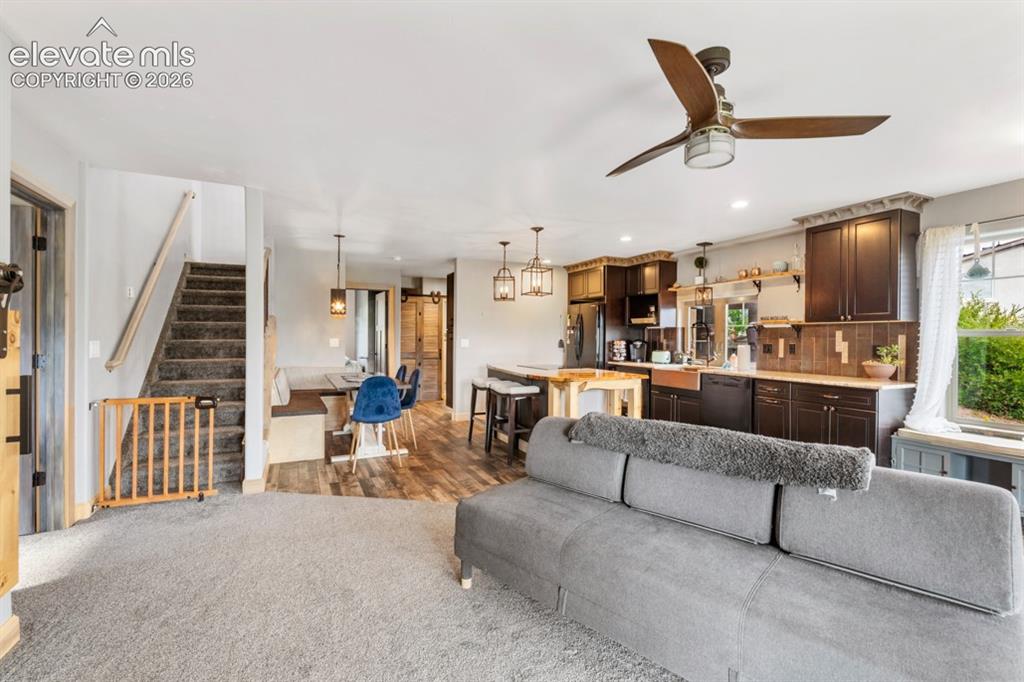 Image 41 of 50: Open-concept living area with wood-finish flooring in the kitchen, dark woo
