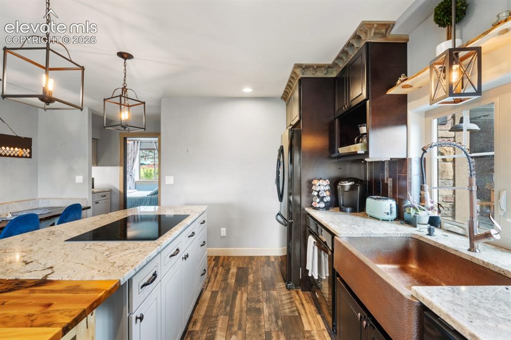 Image 42 of 50: Kitchen featuring a central island with a built-in cooktop, light-toned cab