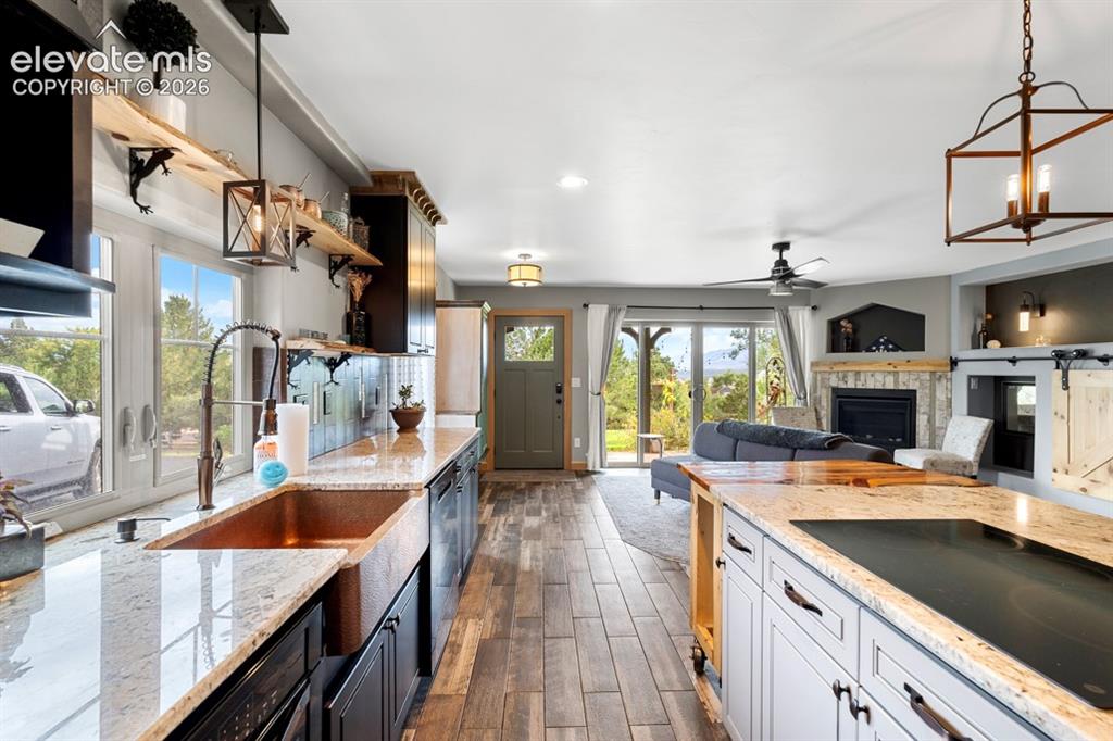 Image 43 of 50: Kitchen featuring an apron-front sink, granite countertops, and wood-finish