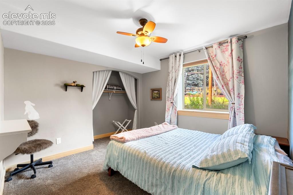 Image 47 of 50: Recessed closet with a clothing rod, ceiling fan with integrated lighting,
