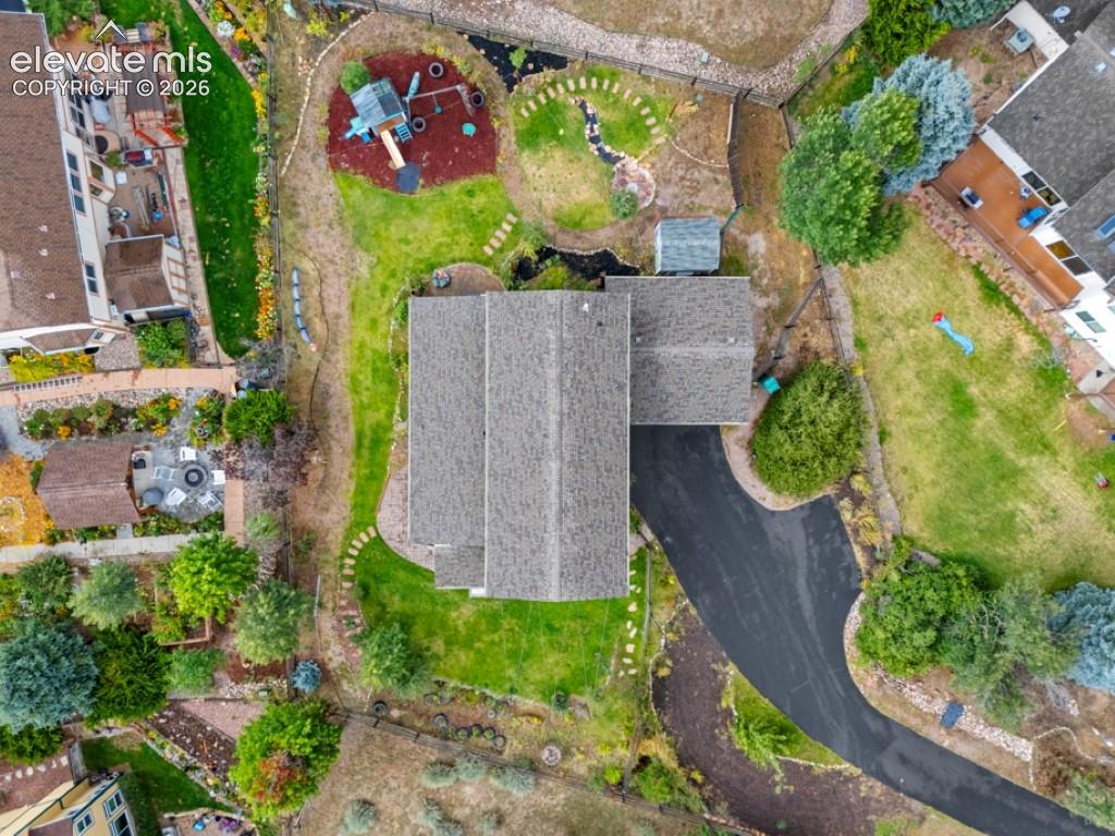 Image 6 of 50: Extensive property featuring a shingle roof, asphalt driveway, multiple lan