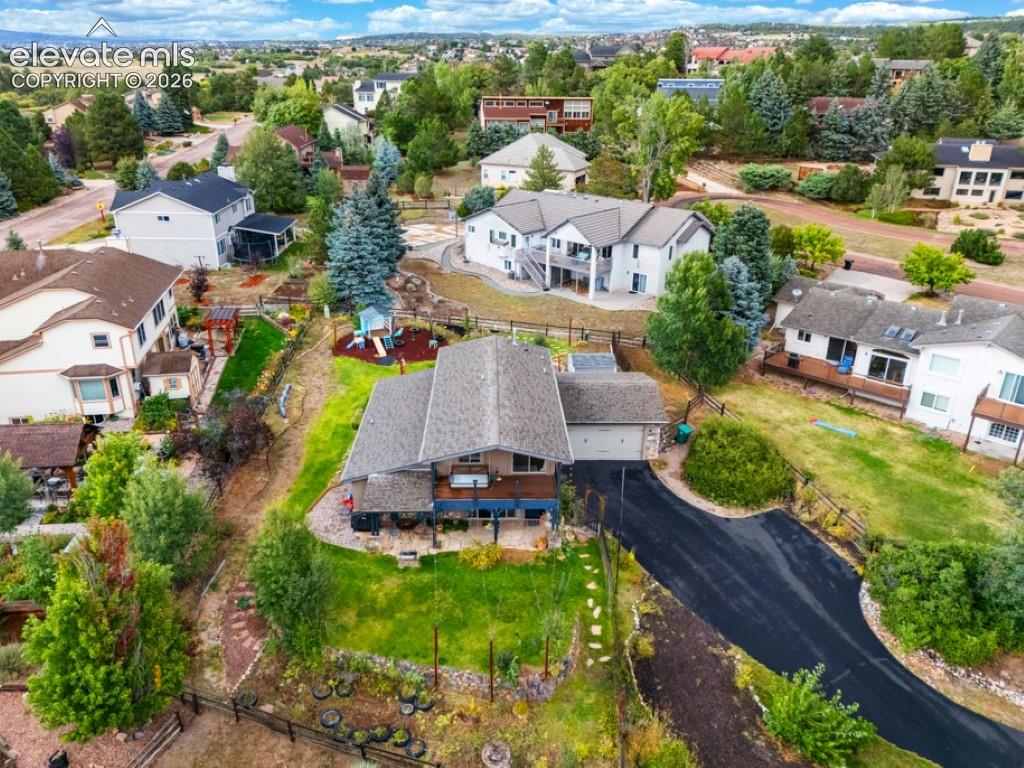 Image 7 of 50: Asphalt driveway, attached garage, sloped backyard, mature trees, multi-lev