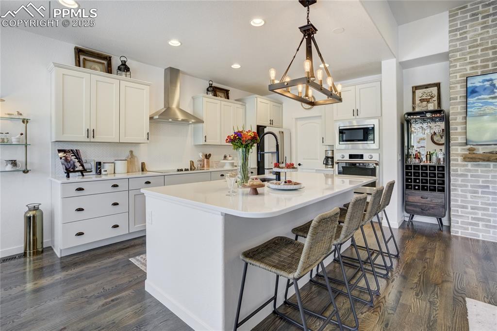 Image 17 of 50: Gourmet kitchen marries form + function with quartz countertops, soft-close