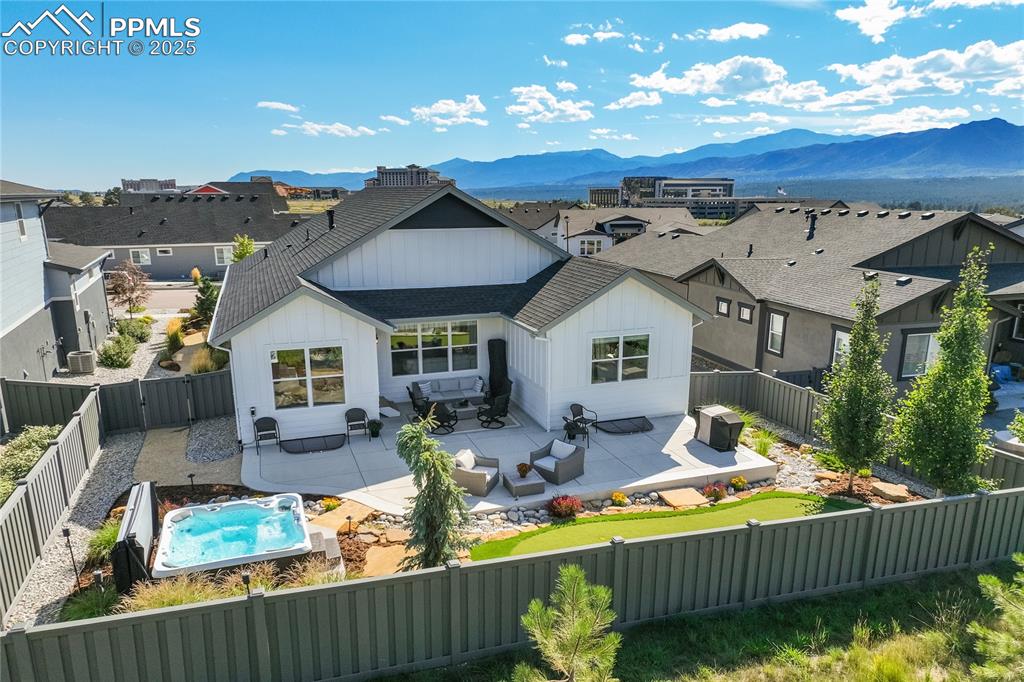 Image 36 of 50: Extended concrete rear patio with mountain views — perfect for outdoor ente