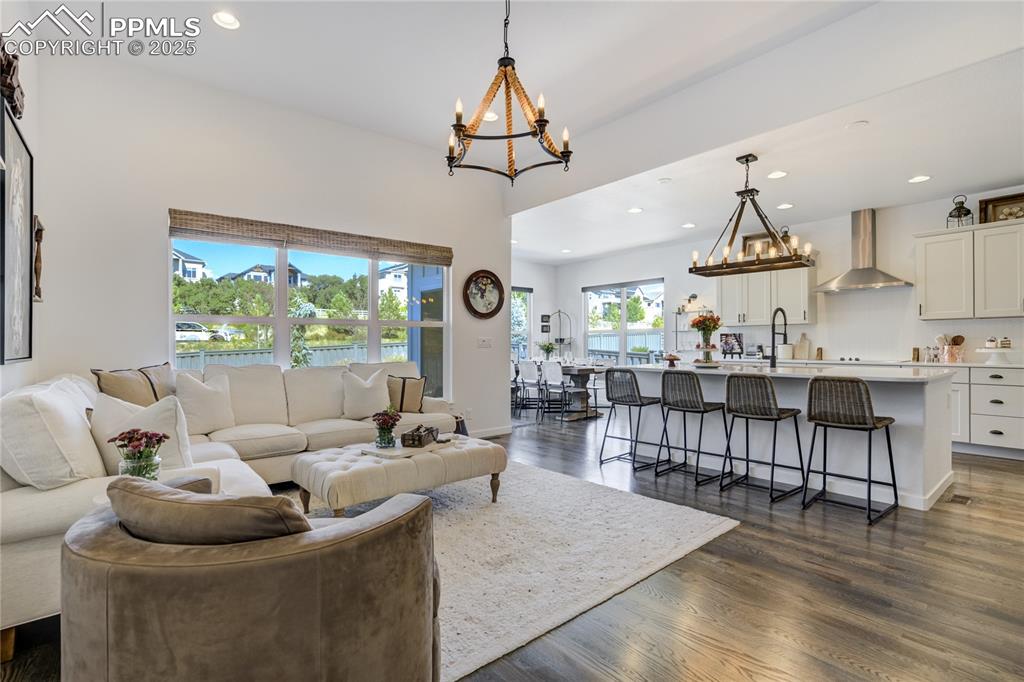 Image 4 of 50: Great room with walls of windows, gleaming hardwood floors, and a floor-to-