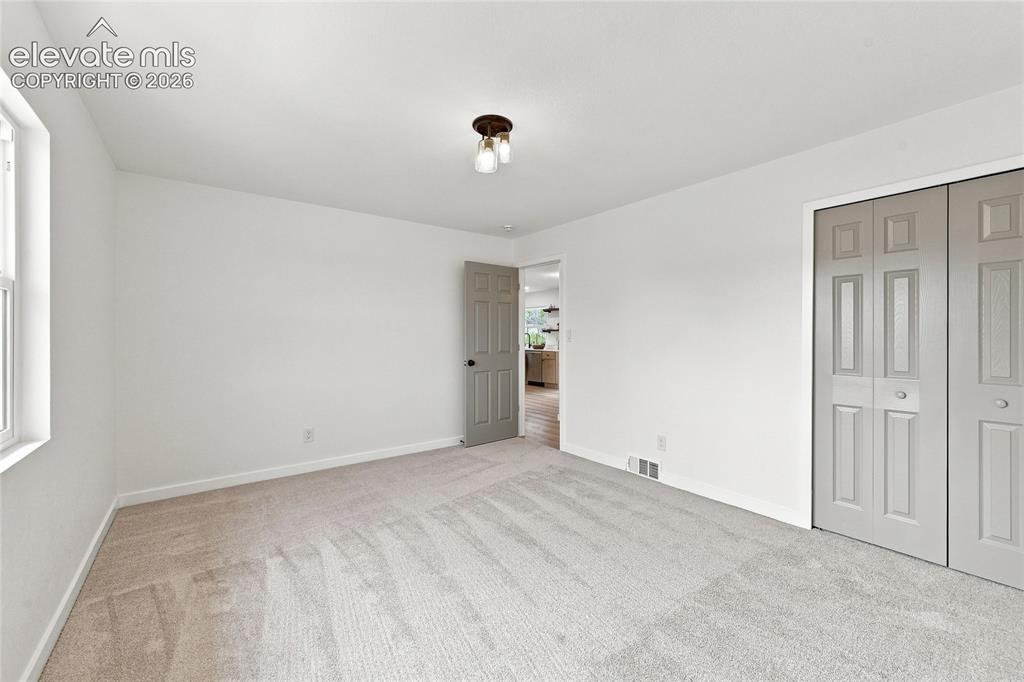Image 14 of 30: Neutral-toned carpet flooring, white painted walls, natural light window, a