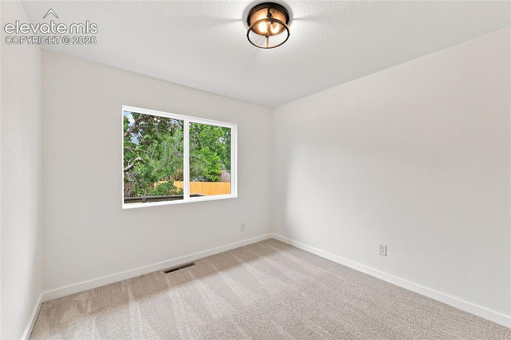 Image 16 of 30: Recessed window with white trim, light neutral carpeting, and a flush mount