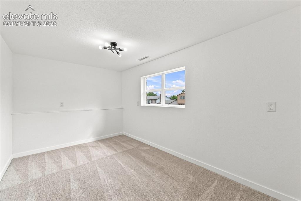 Image 19 of 30: Neutral tone wall paint, contemporary ceiling light fixture, window with ex