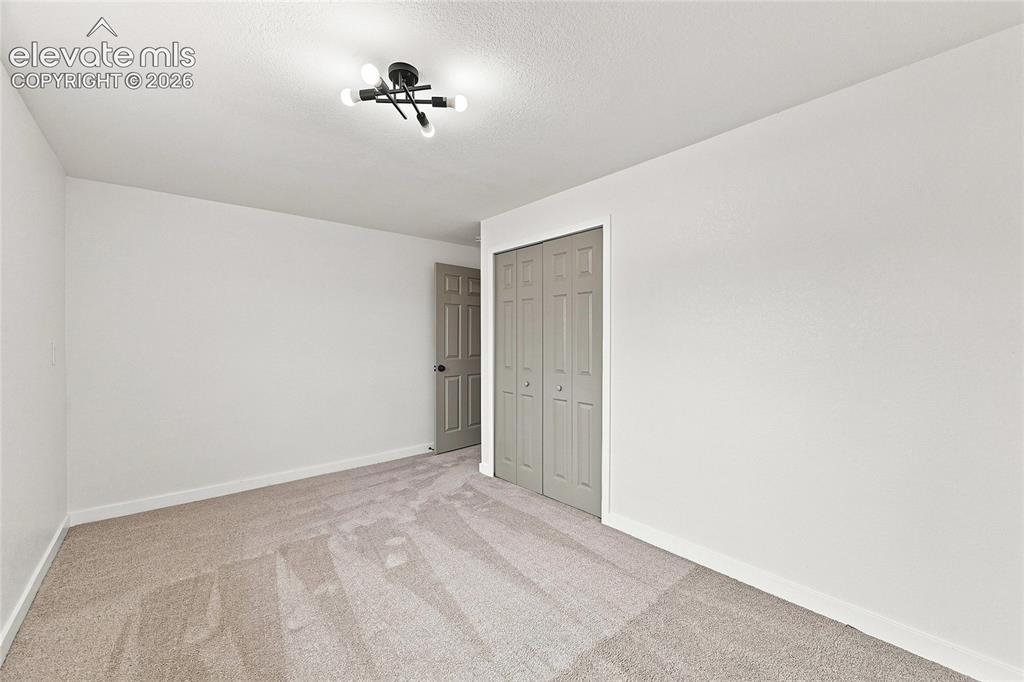 Image 20 of 30: Neutral-toned carpet flooring, white painted walls, a flush-mount ceiling l