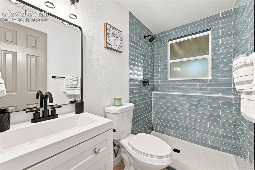 Image 21 of 30: Modern bathroom featuring a vanity with integrated sink, matte black fixtur