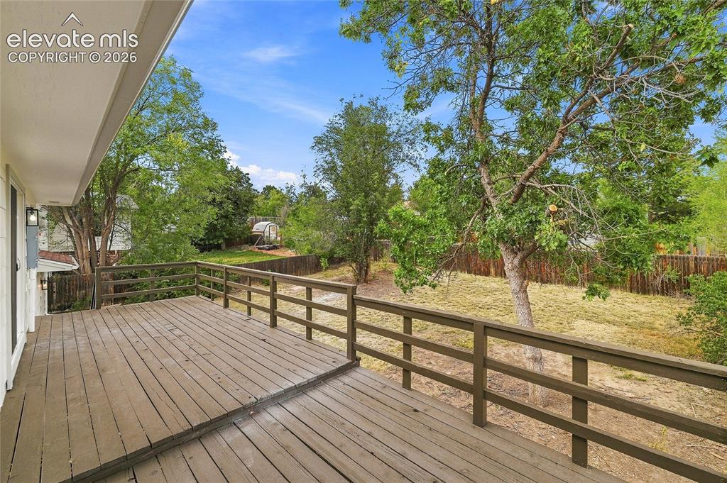 Image 24 of 30: Expansive wood deck with a perimeter railing