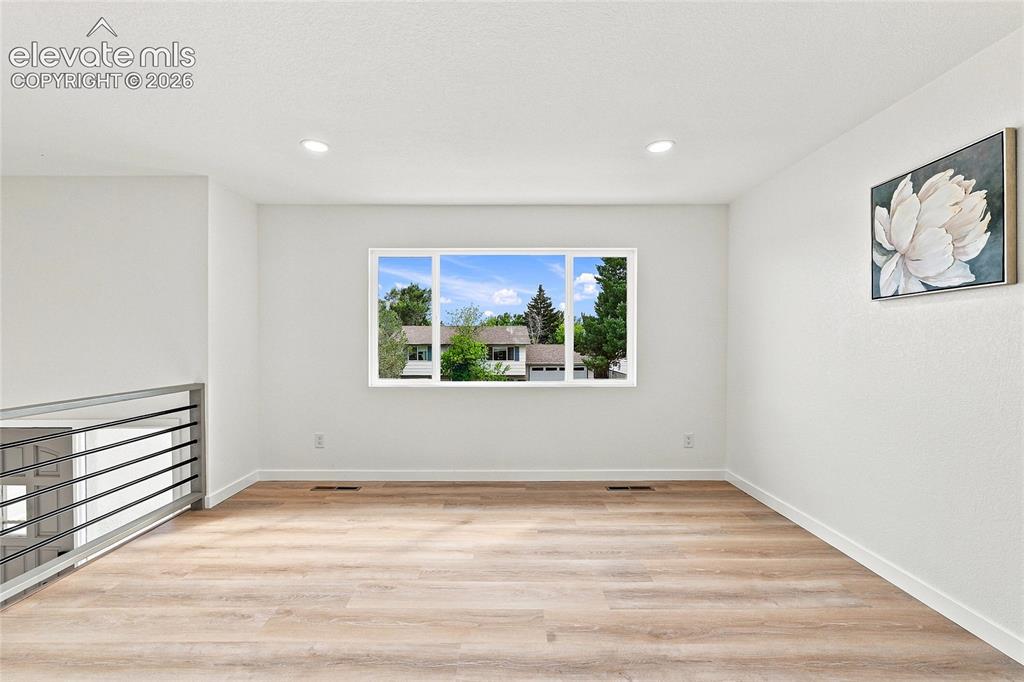 Image 3 of 30: Bright open-concept space featuring wood-finish flooring, recessed lighting