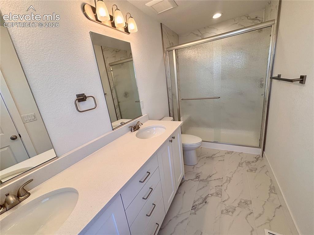 Image 19 of 21: Double vanity with integrated sinks and white cabinetry, complemented by a 
