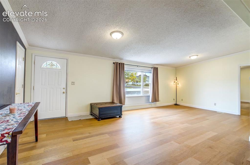 Image 12 of 50: Bright living room with large front window allowing natural light in.