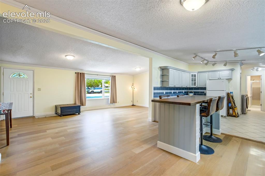 Image 17 of 50: Updated cabinetry, track lighting, and bar seating add both function and st