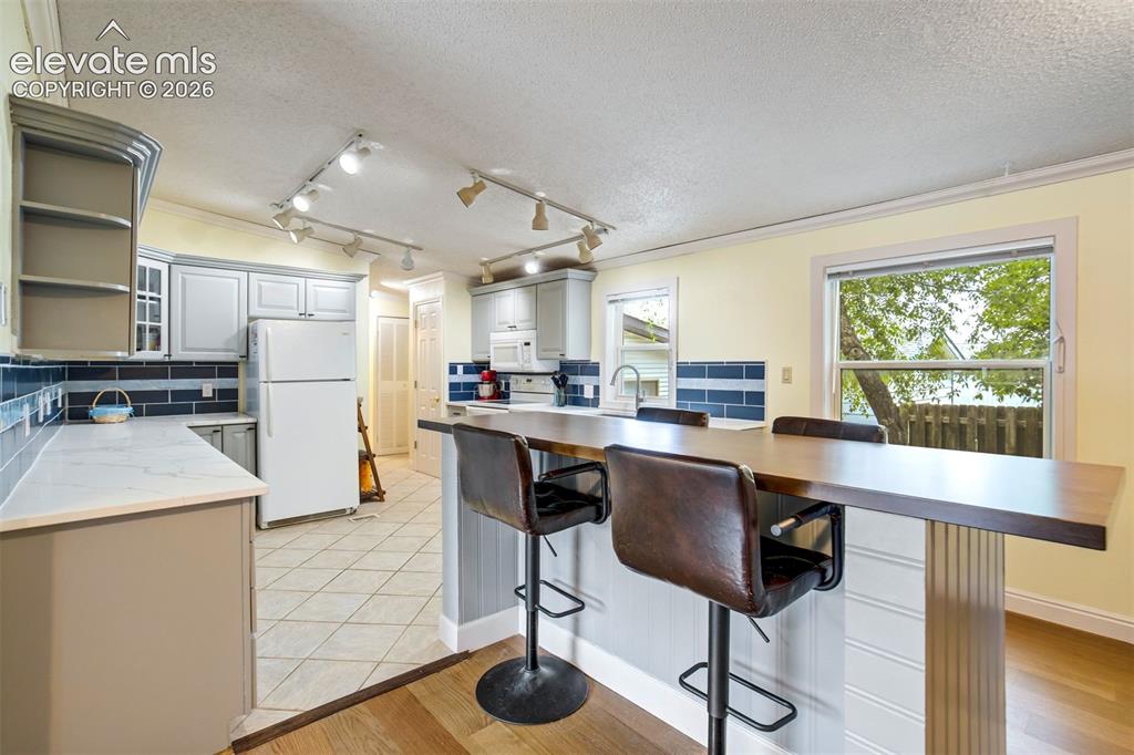 Image 18 of 50: Large center island made from solid wood butcher block provides additional