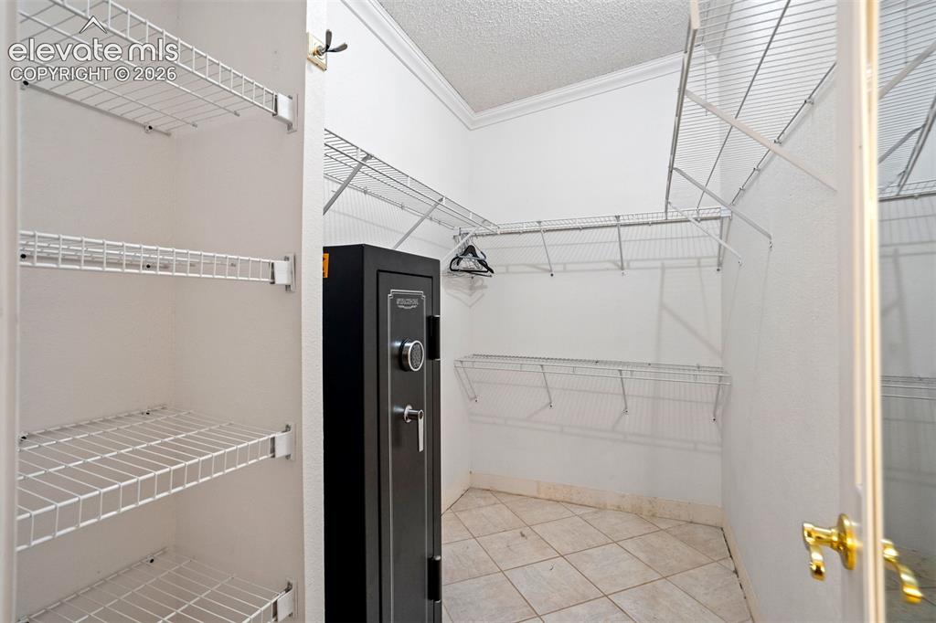 Image 33 of 50: Spacious walk-in closet provides extensive shelving and organized storage o
