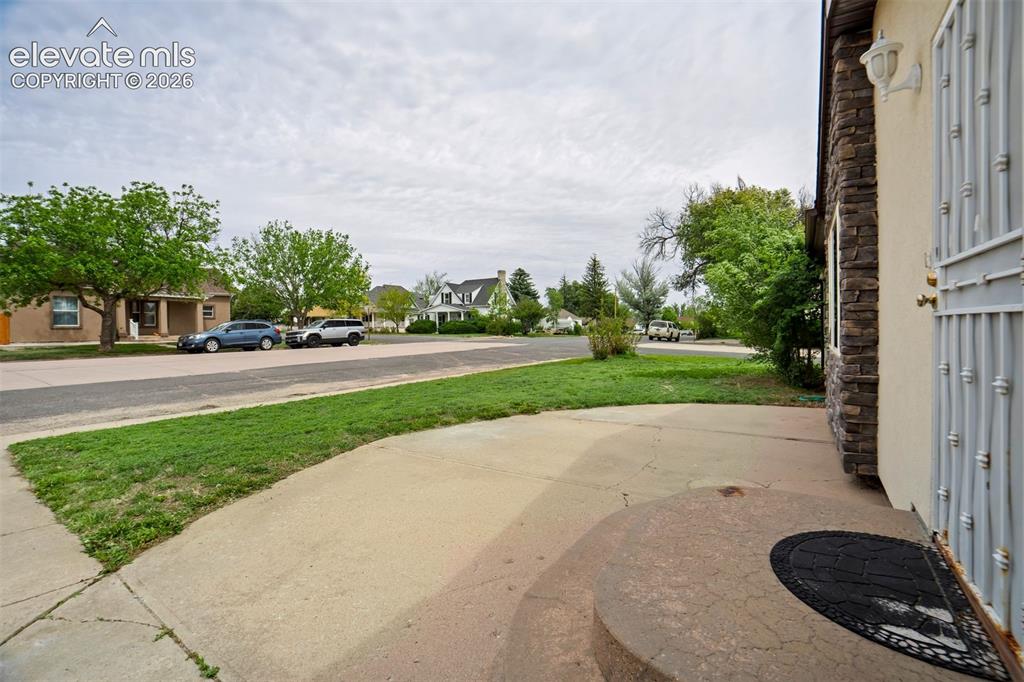 Image 6 of 50: Curved front patio creates an inviting outdoor entry space.
