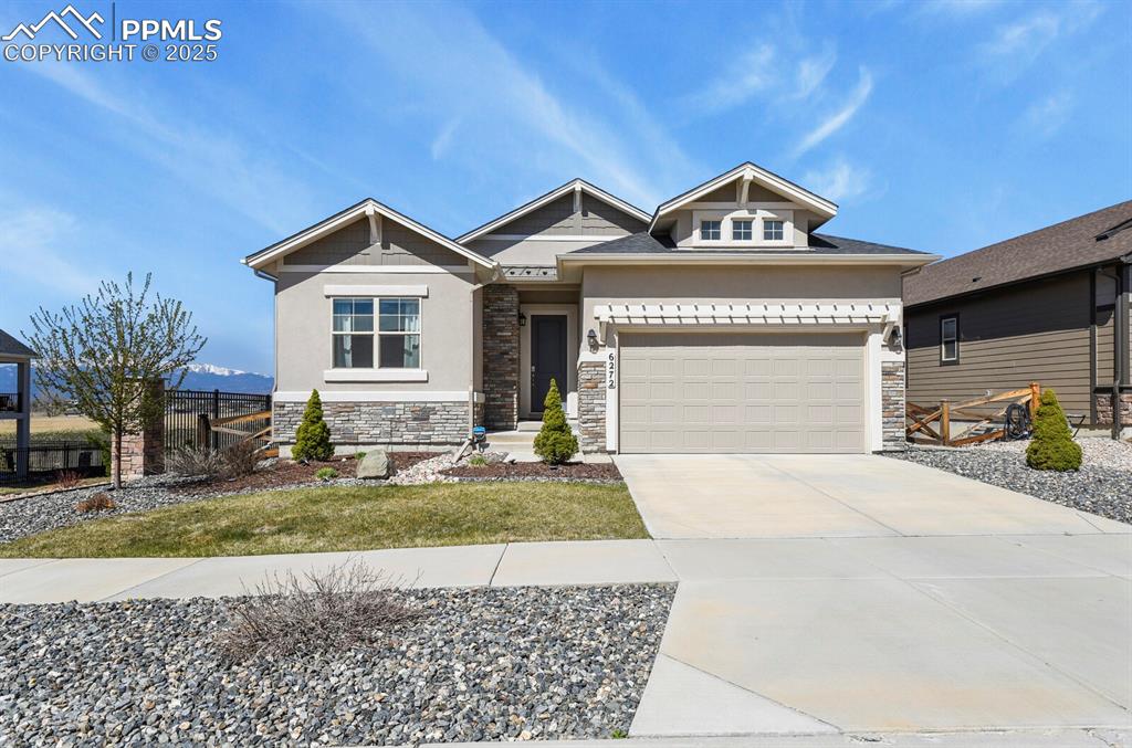 Caption: Craftsman-style home featuring concrete driveway, stone siding, stucco siding, and a garage