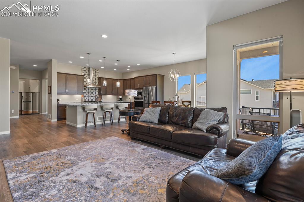 Image 10 of 50: Living room featuring a chandelier, recessed lighting, and dark wood-type f