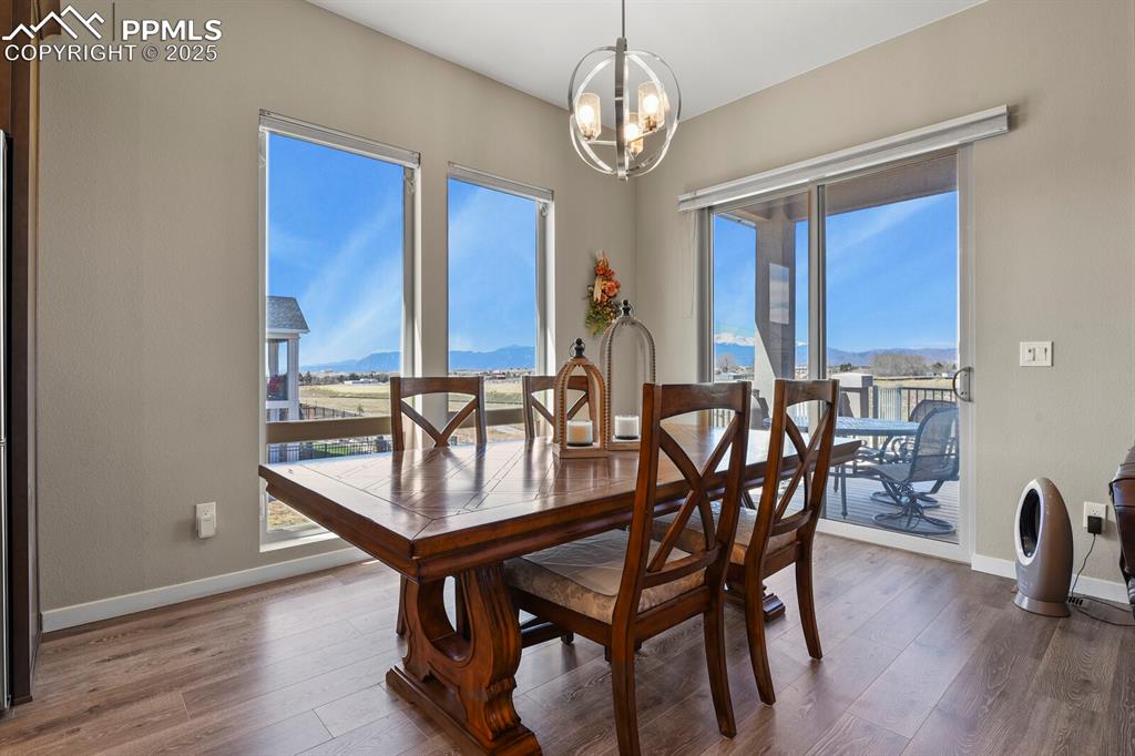 Image 16 of 50: Dining space featuring a mountain view, wood finished floors, and a chandel