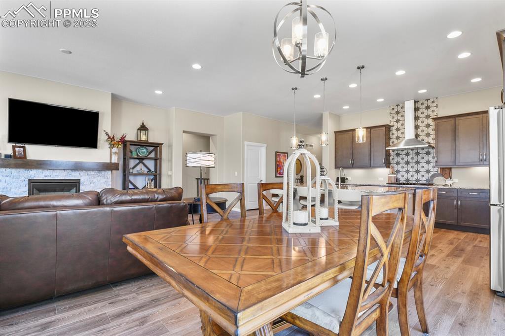 Image 17 of 50: Dining area with light wood-type flooring, recessed lighting, a fireplace, 