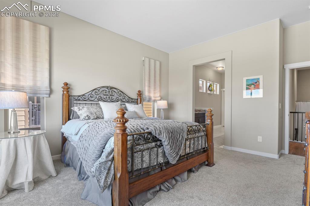 Image 19 of 50: Bedroom with light colored carpet and ensuite bath