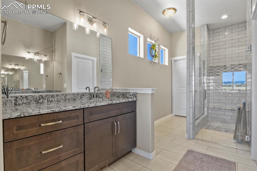Image 22 of 50: Bathroom featuring vanity, a shower stall, and wood tiled floors
