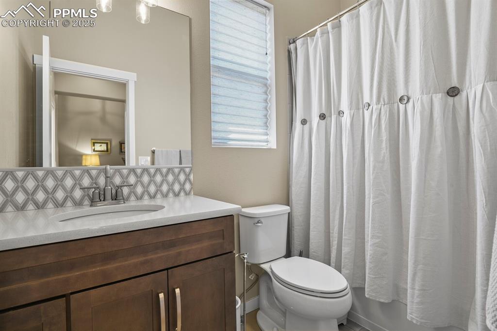 Image 26 of 50: Full bathroom featuring vanity, shower / tub combo with curtain, and decora