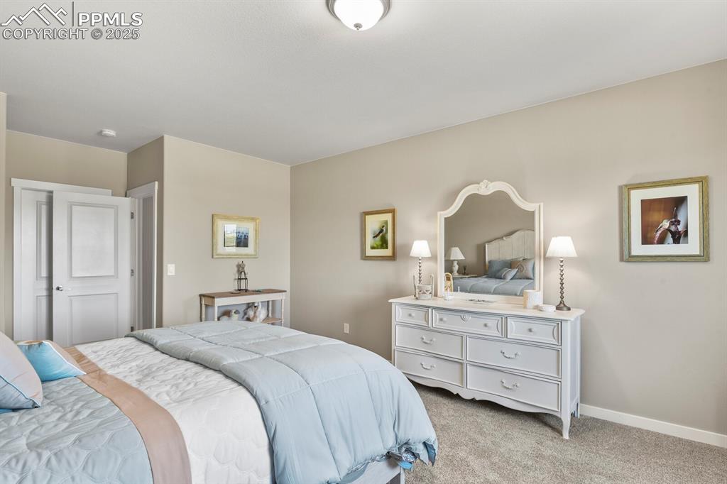 Image 28 of 50: Bedroom featuring light carpet and baseboards