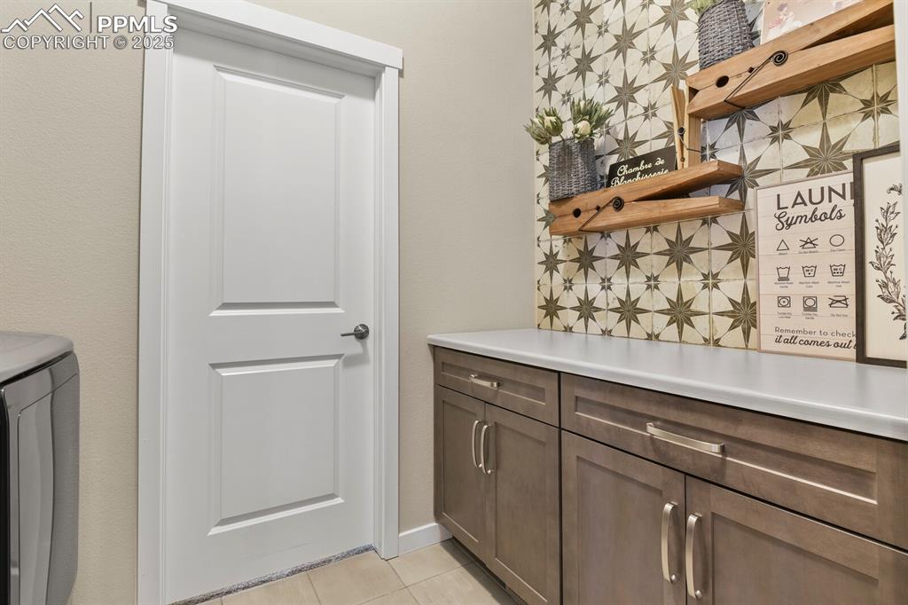 Image 29 of 50: Laundry room with light tile patterned floors