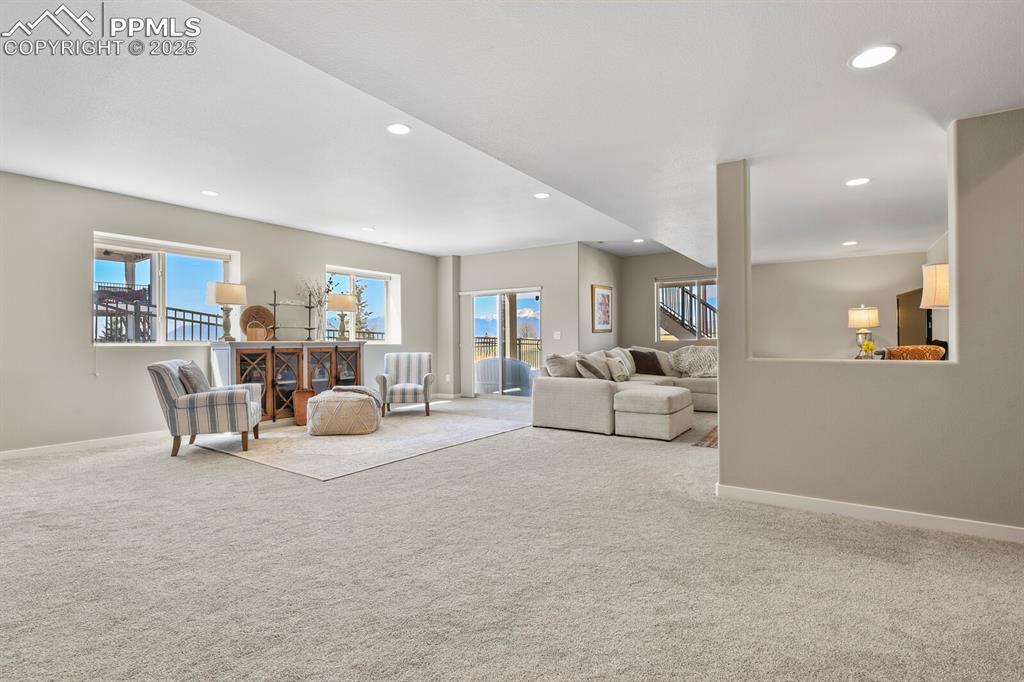Image 32 of 50: Carpeted living room with plenty of natural light and recessed lighting