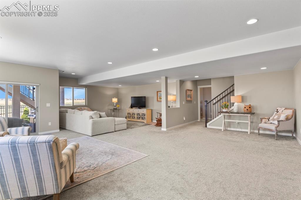 Image 33 of 50: Carpeted living room featuring stairway and recessed lighting