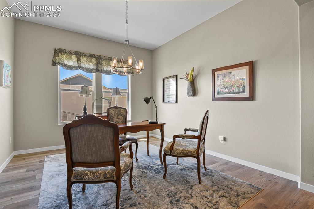 Image 6 of 50: Dining area with wood finished floors, a chandelier, and a desk