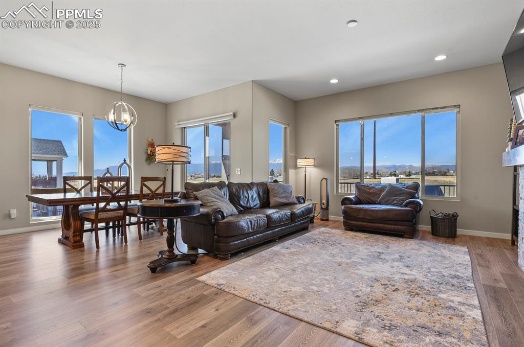 Image 8 of 50: Living room featuring wood finished floors, a chandelier, and recessed ligh