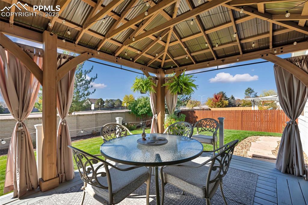 Image 19 of 23: The dream backyard: covered pergola, string lights, and lush landscaping — 