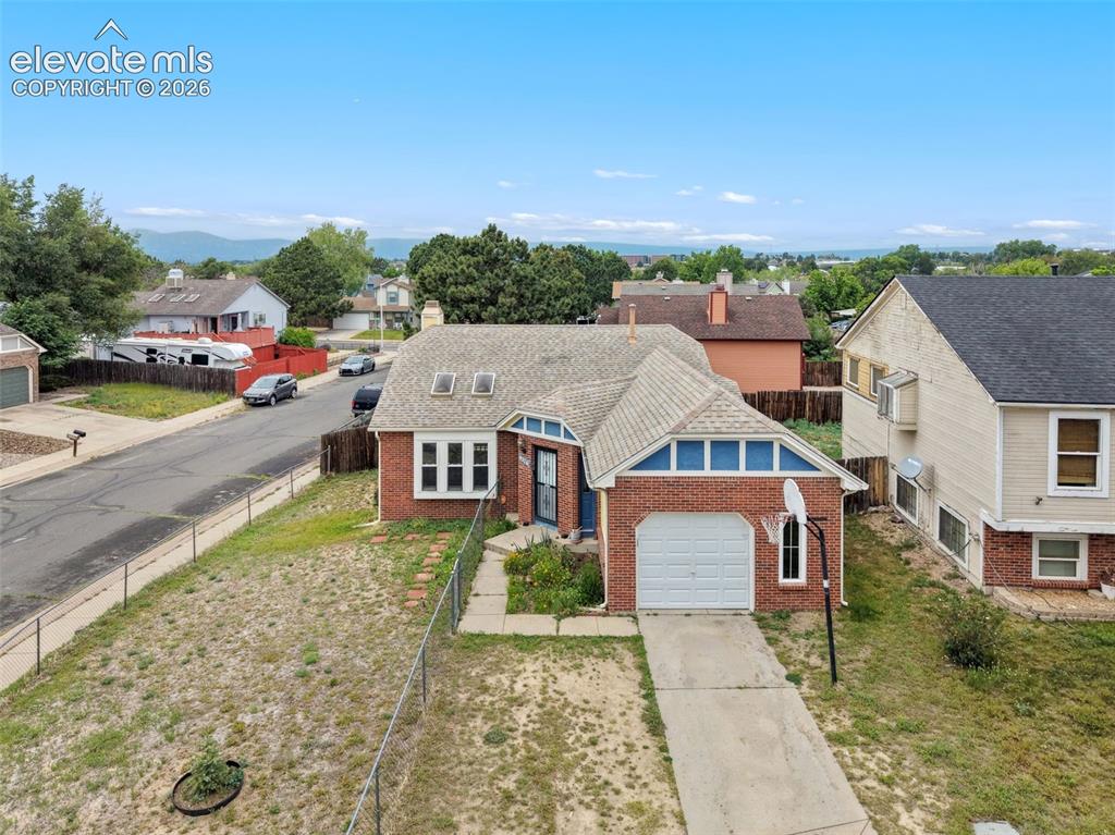 Image 2 of 43: Brick facade residence featuring a front-facing garage with a white door, a