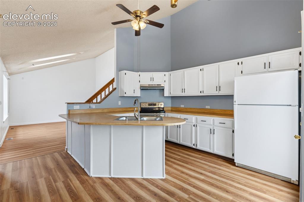 Image 20 of 43: Kitchen featuring white cabinetry, light wood-finish countertops, and wood-