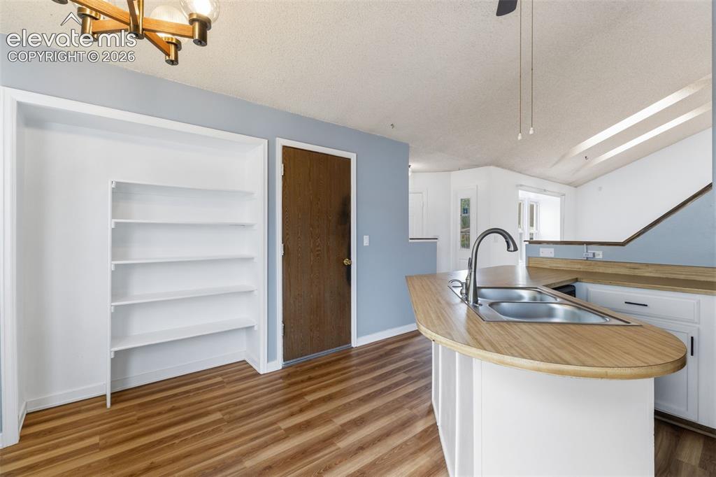 Image 21 of 43: Kitchen area featuring a double basin stainless steel sink, wood-finish cou
