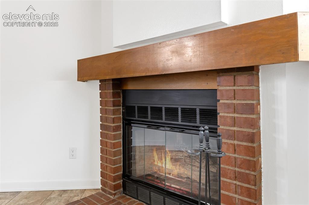 Image 27 of 43: Brick fireplace featuring a wood mantel