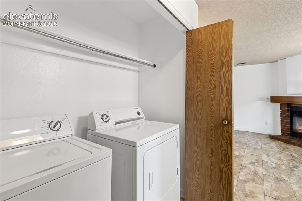 Image 30 of 43: Dedicated laundry area featuring a white washer and dryer pair, an overhead
