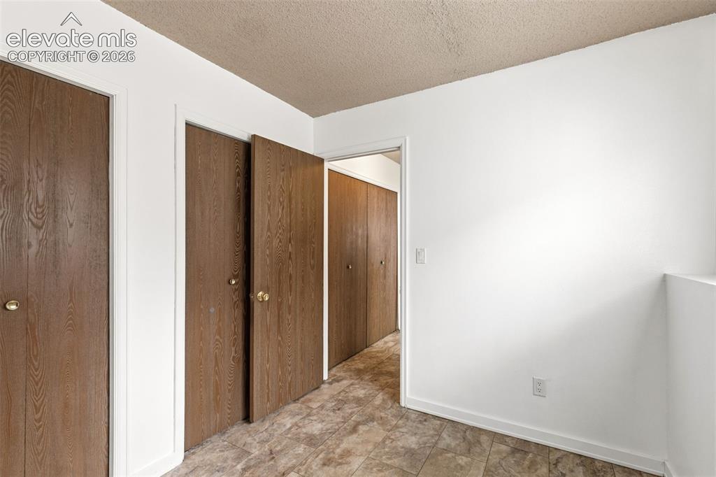 Image 31 of 43: Interior space featuring wood-finish bi-fold doors, neutral wall paint, and