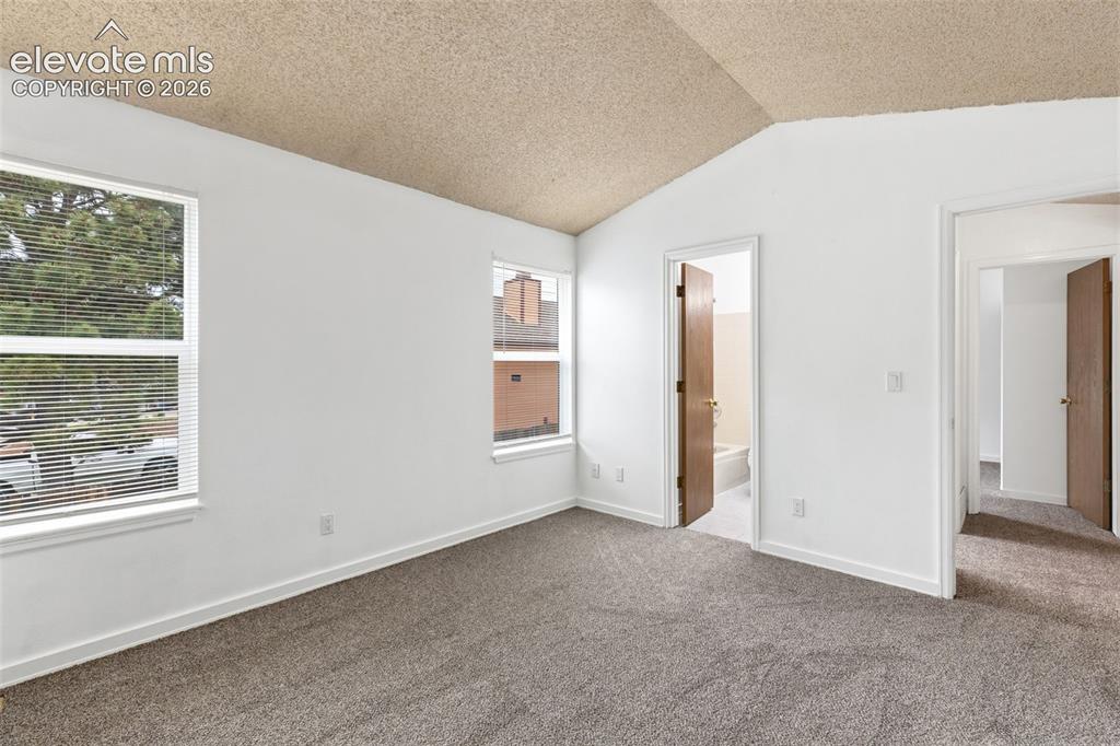Image 33 of 43: Spacious room featuring vaulted ceilings, two windows, wall-to-wall carpeti