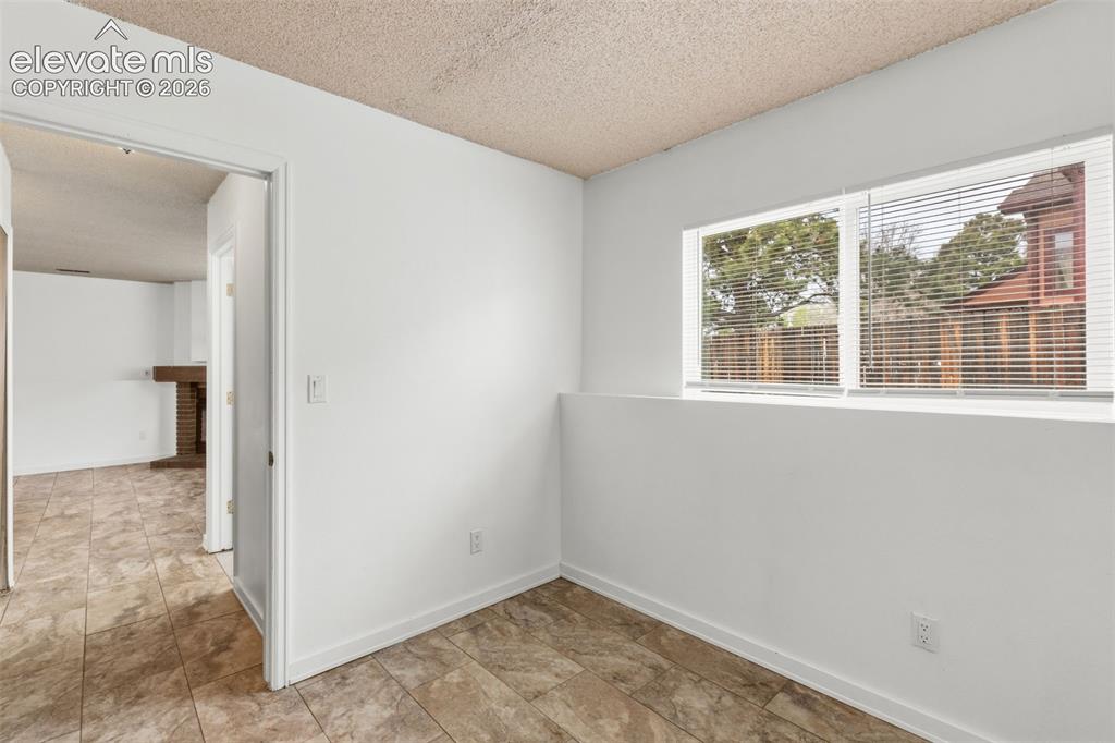 Image 35 of 43: Bright room featuring two large windows with blinds, white painted walls, a