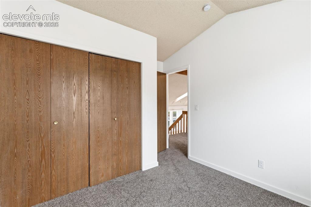 Image 37 of 43: Room featuring wood-finish bi-fold closet doors, neutral gray carpeting, an