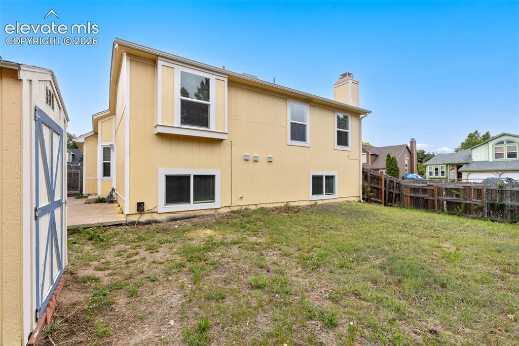 Image 41 of 43: Spacious backyard with a storage shed and wood privacy fencing