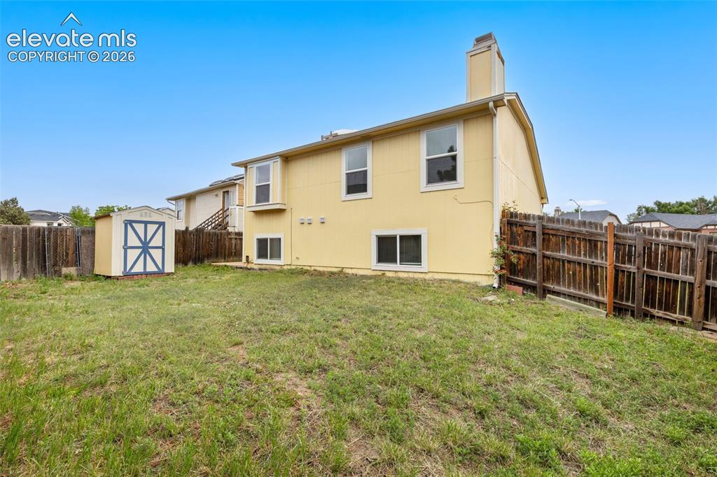 Image 43 of 43: Spacious backyard featuring a storage shed, wood privacy fencing, and a two