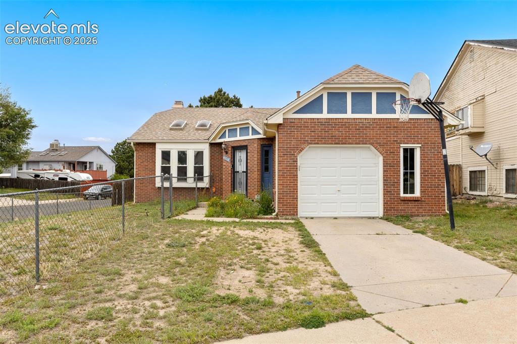 Image 8 of 43: Brick exterior with a white garage door and a concrete driveway